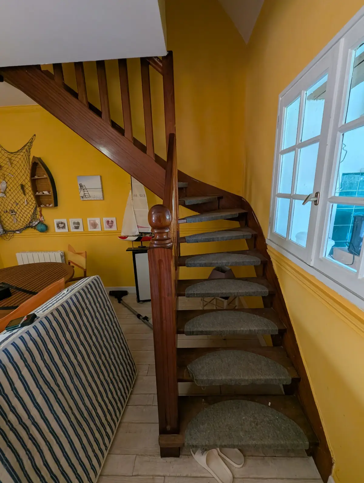 Cage d’escalier d’une maison de bourg de Belz avant travaux, murs jaunes et escalier en bois verni sombre