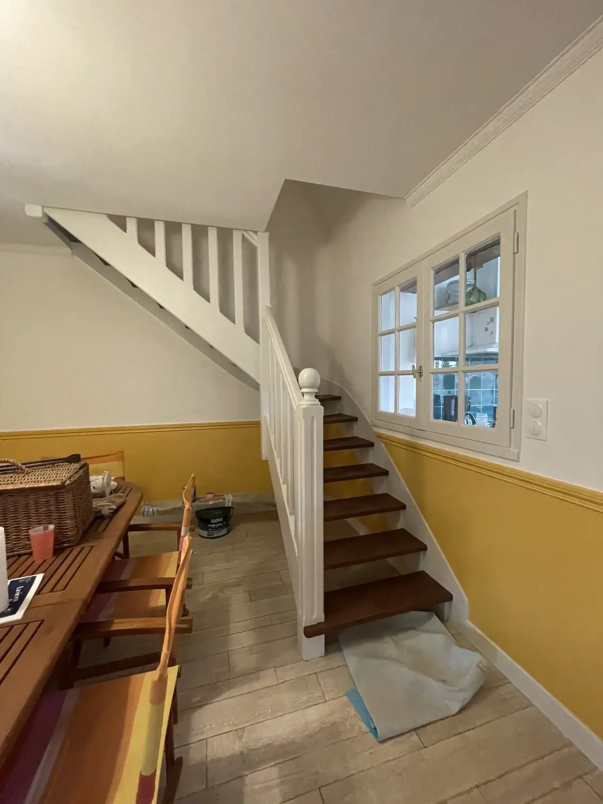 Cage d’escalier d’une maison de Belz après chantier, limon et balustrade en blanc, soubassement jaune conservé sous la cimaise