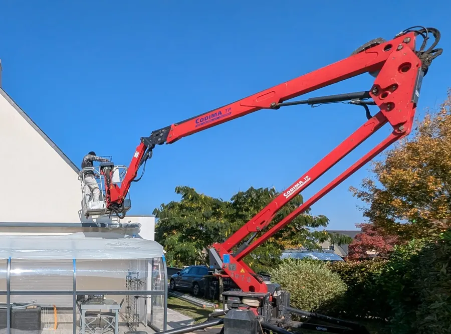 Bras de nacelle déployé le long d’un pignon près de Pleucadeuc, compagnon au travail en façade