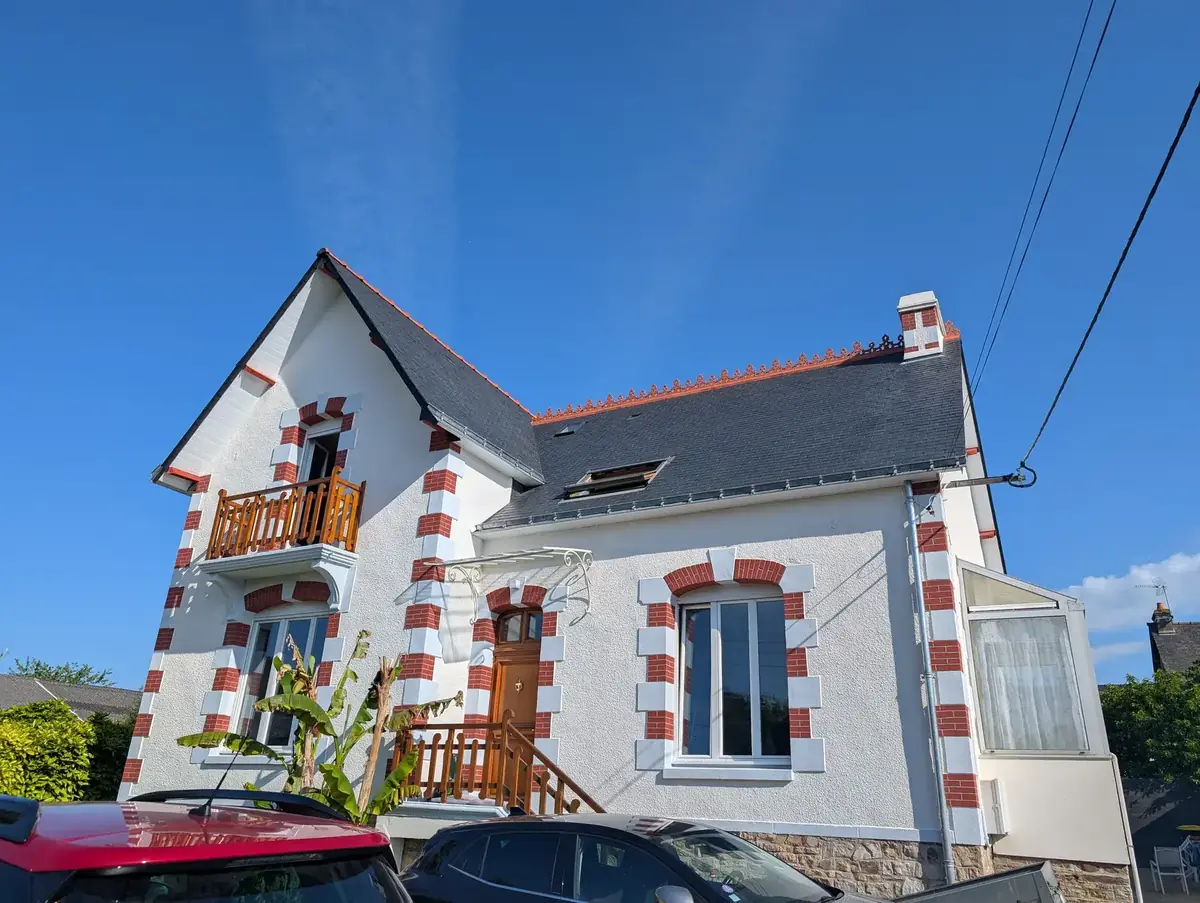 Façade sur rue d’une maison de Malestroit après ravalement, marquise et balcon bois en place