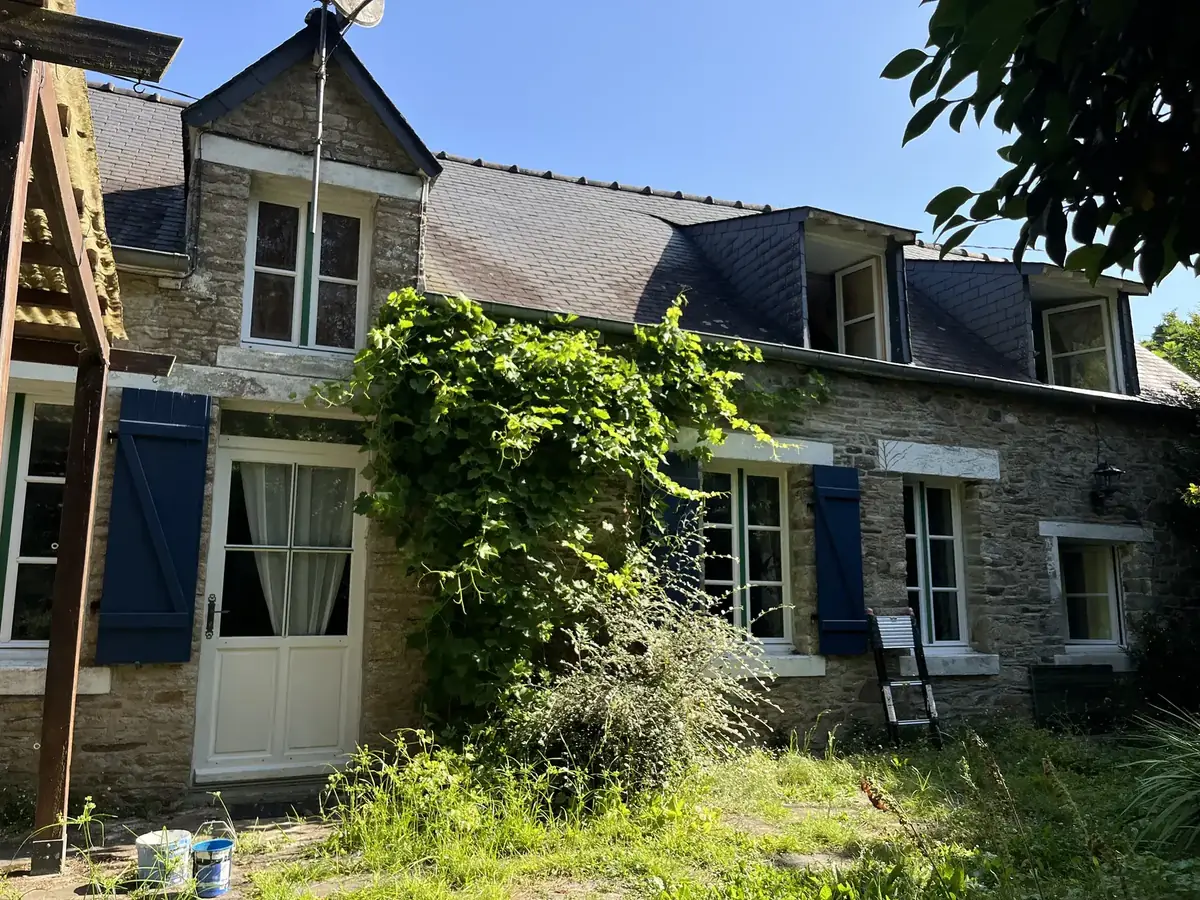 Menuiseries de la longère de Peillac en cours de reprise, échelle et pots de peinture au pied de la façade