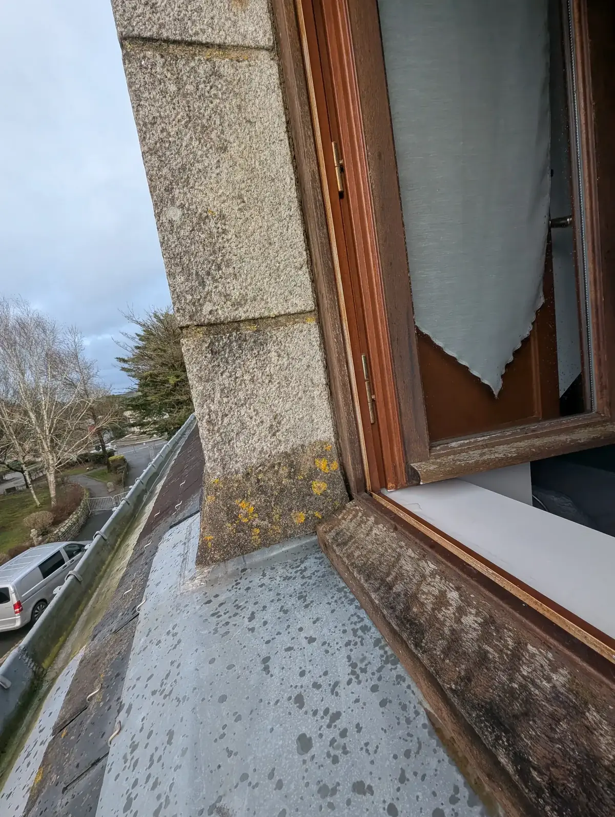 Bas de fenêtre bois usé et jambage en granit piqué de lichen, sur une auberge du bourg de Pluherlin, avant ponçage