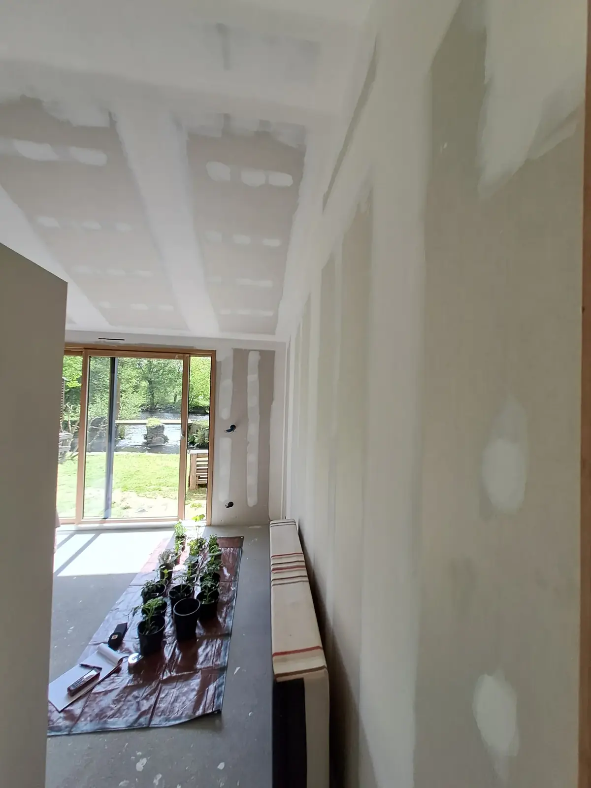 Plafond et cloisons en plaques de plâtre à Saint-Congard, bandes et joints enduits, baie vitrée en fond de pièce