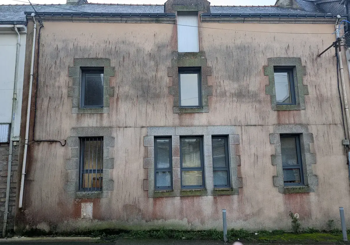 Façade d’un immeuble de bourg de Sarzeau avant ravalement, enduit noirci par les mousses et marqué de coulures sous la rive