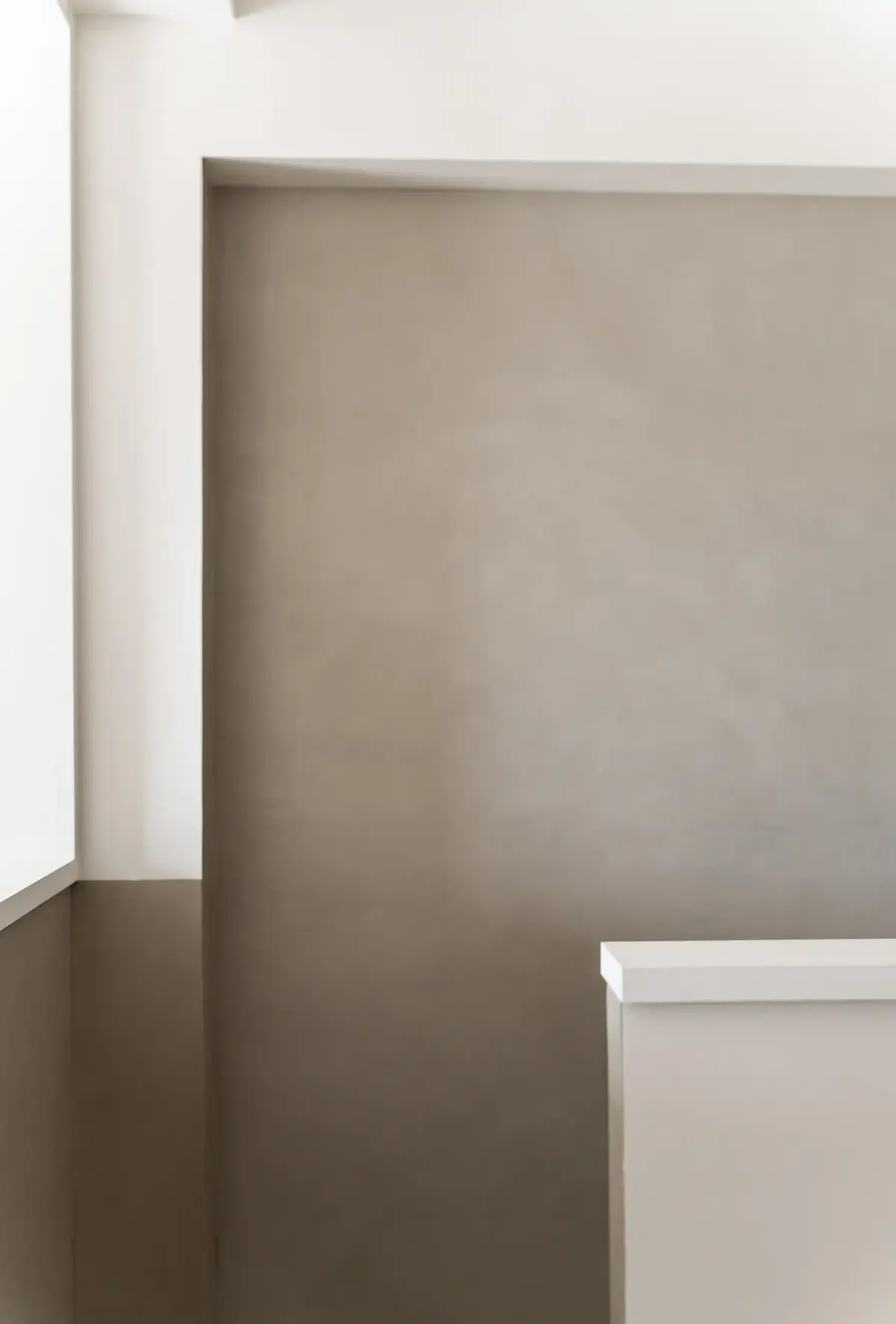 Angle de mur enduit gris taupe, arêtes nettes