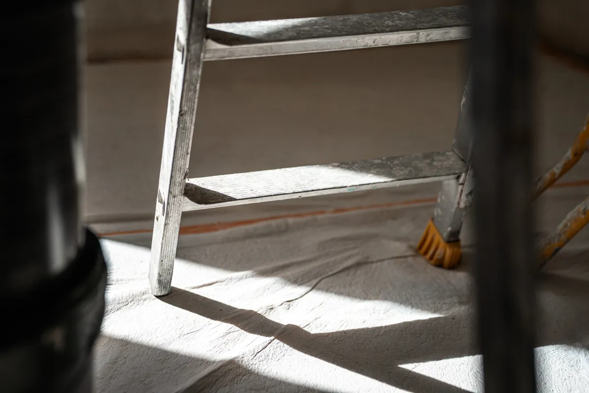 Sol protégé par une bâche, escabeau en place