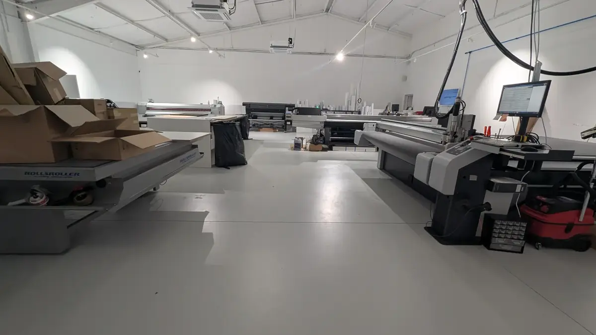 Atelier remis en service sur son nouveau sol gris, machines et postes de travail en place