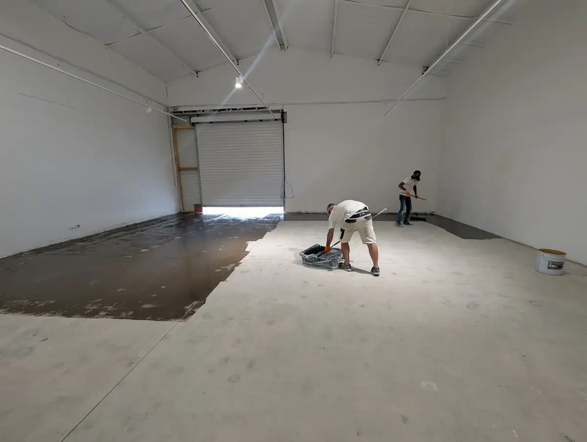 Couche d’accroche en cours d’application, au rouleau, sur le béton préparé