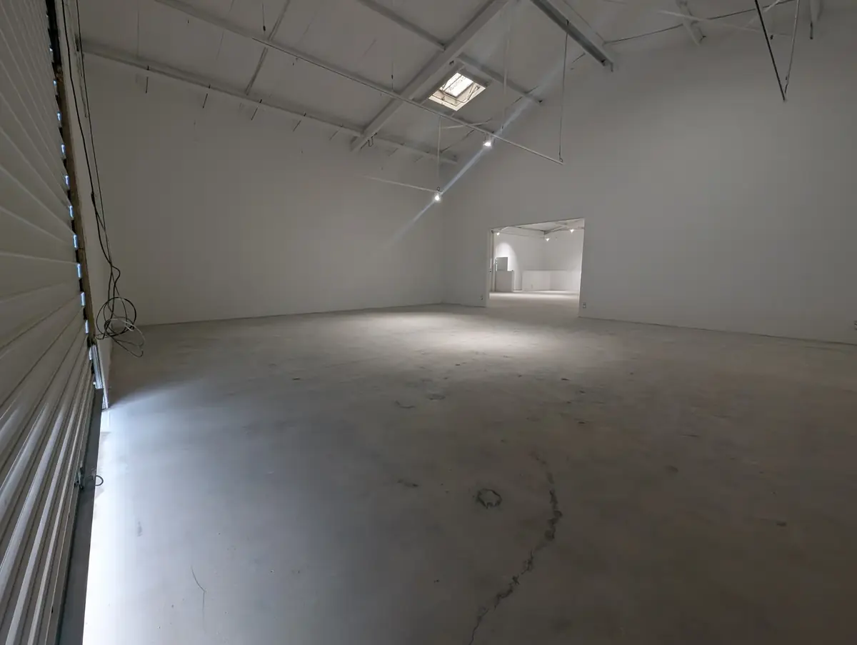 Grand hall d’atelier vide avant les travaux de sol, béton nu