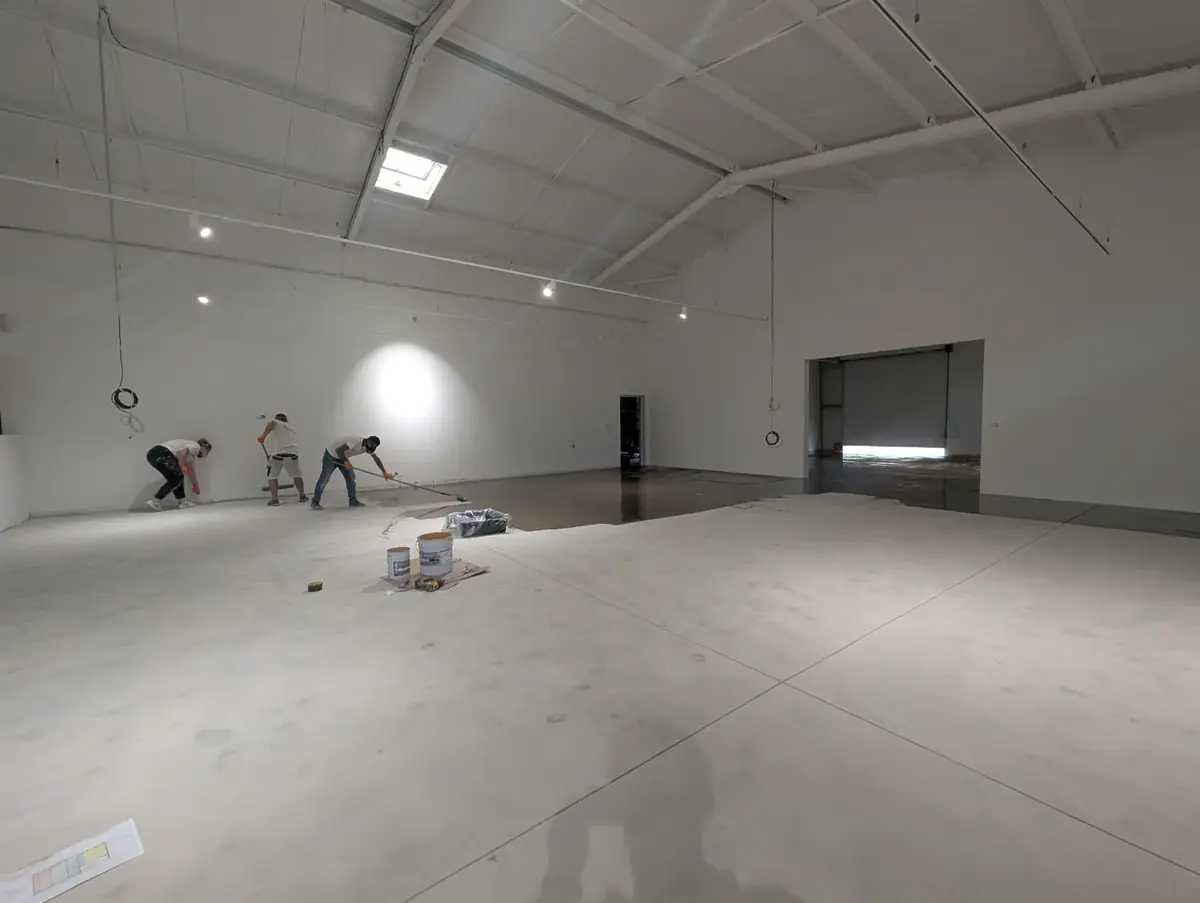 Application de la couche d’accroche sur le béton d’un atelier