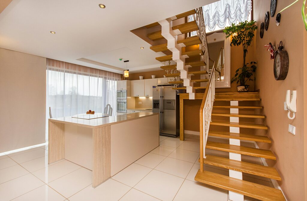 Photo large d'une salle à manger avec un escalier en bois à droite.